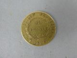 a gold coin with a wreath on it on a white surface