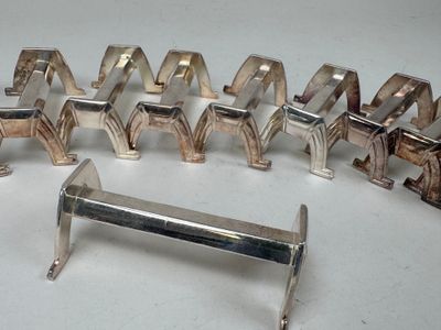 plusieurs pièces métalliques argentées sont disposées sur une surface blanche