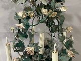 a chandelier made of flowers and candles on a table