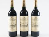 three bottles of wine sitting next to each other on a white surface
