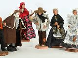 five figurines of people dressed in historical clothing