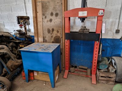 a picture of a garage with a blue table and a red machine