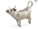 une image représentant une figurine de vache en argent sur fond blanc