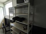 a microwave on a shelf in the corner of a room