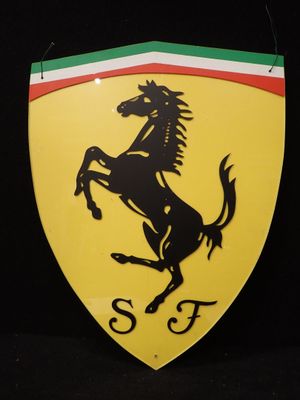 logo Ferrari sur un bouclier jaune orné d'une bande rouge, blanche et verte
