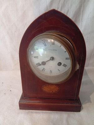 une petite horloge en bois avec des chiffres romains