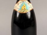 une bouteille de vin rouge sur fond gris, avec une étiquette