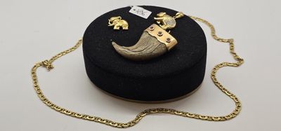 une boîte noire entourée d'une chaîne en or et un collier orné d'un éléphant