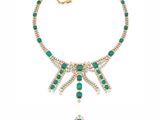 an emerald and diamond necklace with a cross pendant