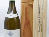 une bouteille de vin dans un coffret en bois à côté d'une bouteille de vin
