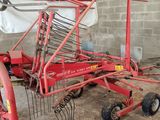 une photo d'un tracteur agricole rouge dans une grange