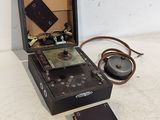 une radio à l'ancienne posée sur une table, à côté d'un casque audio