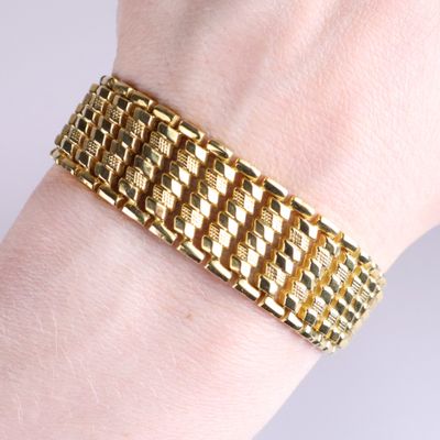 bracelet plaqué or au poignet d'une femme, muni d'un fermoir en diamant