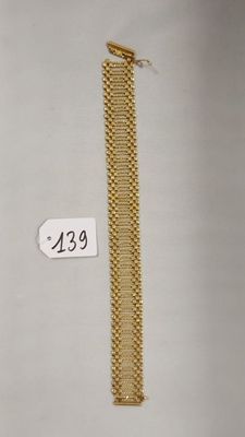 un gros plan d'un bracelet en or sur lequel figure un numéro