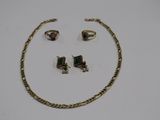 two pieces of jewelry sitting on top of a white surface