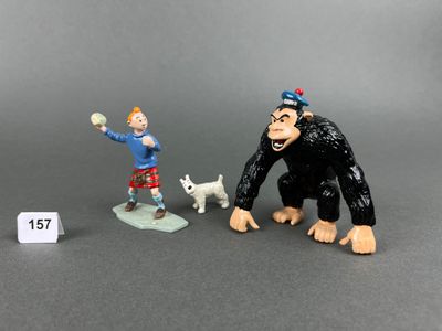 two figurines of a monkey and a man with a dog
