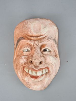 an image of a clay mask of a man with a smile on his face