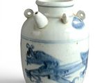 a blue and white vase with two handles on a white surface
