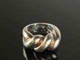 a close up of a silver ring on a black surface
