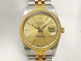 une image représentant une montre Rolex dorée et argentée sur fond blanc