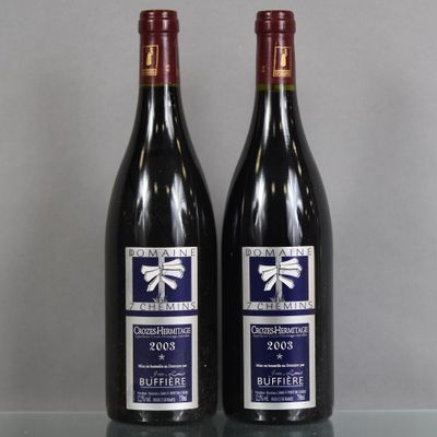 two bottles of red wine sitting on top of a glass table