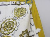 a close up of a yellow and white scarf with a gold key on it