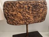 a large piece of rock sitting on a table next to a glass of water