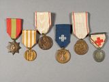 five medals and a medal on a gray surface