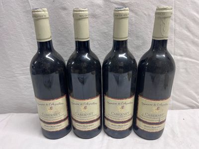 four bottles of wine are lined up on a table