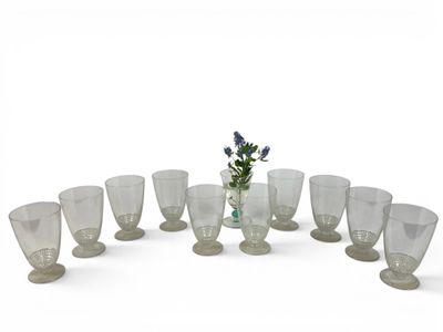 des bouteilles et des verres sont disposés en cercle sur une surface blanche