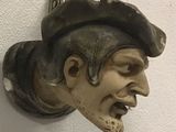 a statue of a man with a hat on a wall