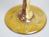 a yellow vase with a brown base on a white table