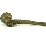 an old pipe with a brass handle sitting on a white surface