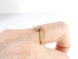 a person holding a gold ring with a diamond on it