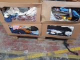 two cardboard boxes with clothes in them on a pallet