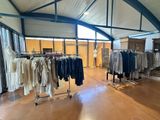 a large room with a lot of clothes on a rack