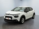 Une Citroën blanche est garée dans une pièce blanche
