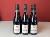 quatre bouteilles de vin sont alignées sur un comptoir