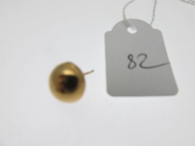 une pomme dorée et une étiquette de prix posées sur une table