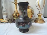 a vase that is sitting on a table next to a lamp