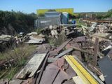 a pile of junk in a yard with a truck in the background