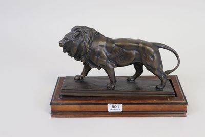 bronze statue of a lion on a wooden base on a white background