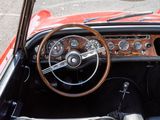 a steering wheel and dashboard of a red sports car