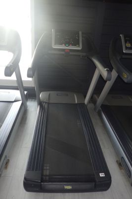 deux tapis de course dans une salle de sport dotée d'une fenêtre