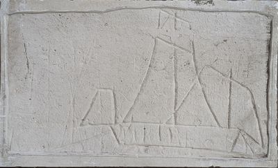 relief of a boat and a man on a boat on a stone block