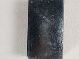 a small black object on a white surface that looks like a mirror