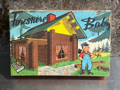 une petite boîte en bois sur laquelle figure l'image d'un homme devant une maison