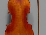 an old violin sitting on top of a table next to a bow