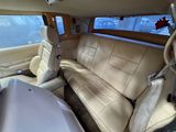 beige leather seats in the back of a car with a tv on the wall