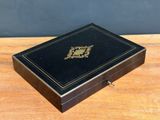 a black box with a gold emblem on it sitting on top of a wooden table